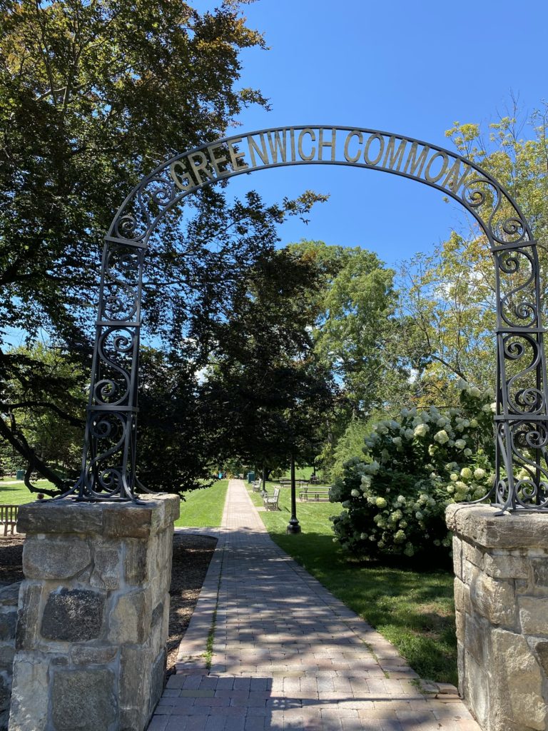 The entrance to Greenwich Common featuring an arch with the words "Greenwich Common."