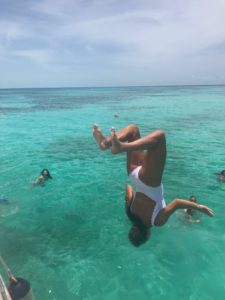 This picture is of me doing a backflip off of the boat. You can also see in this image the blue water and some other people who were in the water. 