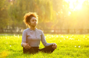 Woman takes a deep breath in the outdoors to relax 