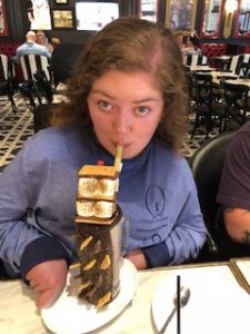 A girl drinking a giant chocolate milkshake